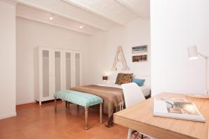 a bedroom with a bed and a table and a desk at Click&Flat Europa Fira Apartments in Hospitalet de Llobregat