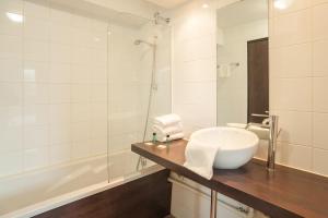 a bathroom with a sink and a bath tub at City Résidence Chelles in Chelles