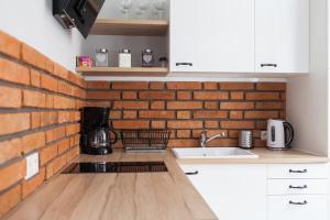 a kitchen with a brick wall and a counter top at Fahrenheit Centrum Ogarna in Gdańsk