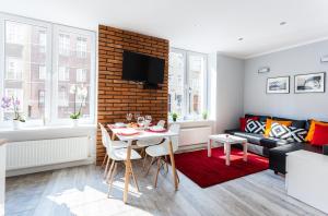 a living room with a table and a couch at Fahrenheit Centrum Ogarna in Gdańsk