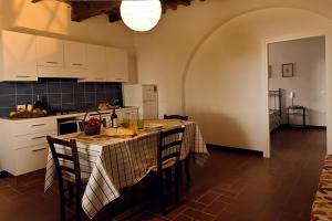 a kitchen with a table and chairs in a kitchen at Agriturismo Poggio Agli Ulivi in Riotorto