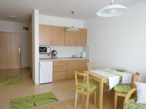 cocina y comedor con mesa y sillas en Jade Apartment, en Hegykő