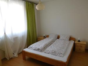 1 dormitorio con 1 cama con 2 almohadas y ventana en Jade Apartment, en Hegykő