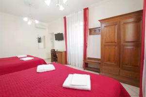 ローマにあるAnthony House, Via Villafranca 2, Castro Pretorioのベッドルーム1室(ベッド2台、赤いシーツ、タオル付)