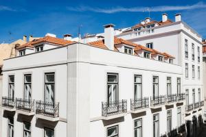 um edifício branco com um telhado vermelho em The Lisboans Apartments em Lisboa