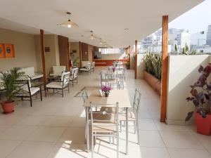 a restaurant with tables and chairs and plants at Hotel Las Palmas in Lima