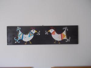a painting of three chickens hanging on a wall at Sa 'E Jana in Orgosolo
