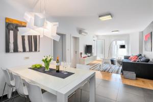 a kitchen and living room with a white table and chairs at Apartment Lungomare in Pula