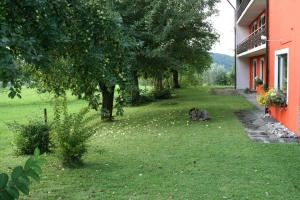 Ein Hund, der im Gras neben einem Haus liegt. in der Unterkunft Bergener Hof in Bergen