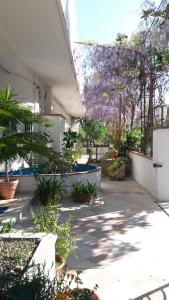 un giardino con fiori viola appesi a un edificio di Hotel Calla' a Policoro
