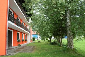 an orange building with a tree next to a yard at Bergener Hof in Bergen