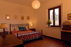 a bedroom with a bed and a window at Agriturismo Poggio Agli Ulivi in Riotorto