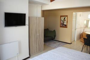 uma sala de estar com um sofá e uma televisão de ecrã plano em Tikay Suite Hotel em Copiapó