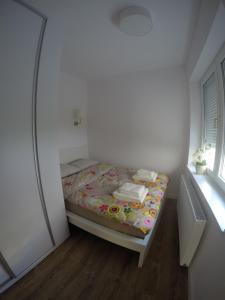 グディニャにあるStarowiejska 9 Apartmentsの窓付きの部屋にベッドが備わる小さなベッドルーム1室が備わります。