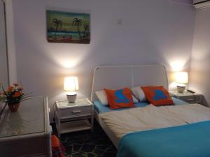 um quarto com uma cama e duas mesas de cabeceira com candeeiros em Love Greece Apartments em Nafplio