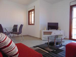 a living room with a couch and a table and a tv at Duplex 8 in Puerto de Mazarrón