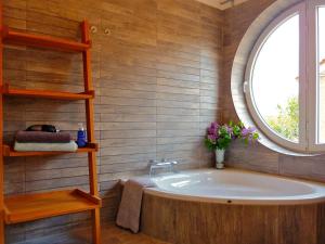 a bathroom with a bath tub and a window at Schlei Resort Marina Hülsen in Kosel