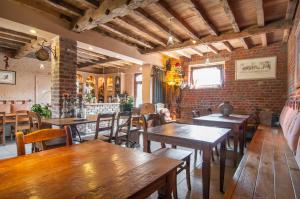 un restaurant avec des tables et des chaises et un mur en briques dans l'établissement La Ferme Des Eglantines, à Nivelles