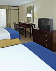 Habitación de hotel con 2 camas y escritorio con TV. en Holiday Inn Express Little Rock-Airport, an IHG Hotel, en Little Rock