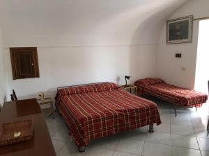 ポンツァにあるMagi - Azzurraのベッド2台、テーブル、ベッド1台、テーブル1台が備わる客室です。
