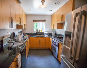 eine Küche mit Holzschränken und einem Kühlschrank aus Edelstahl in der Unterkunft PodShare Venice in Los Angeles