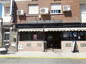 un edificio de ladrillo en una calle con una motocicleta estacionada fuera en Pension San Marcos, en Alovera