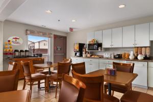 a restaurant with tables and chairs and a kitchen at Super 8 by Wyndham Yellowknife in Yellowknife