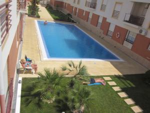 a person laying on the grass next to a swimming pool at Luxury Duplex with pool in Cabanas de Tavira