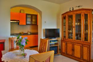 a kitchen with orange cabinets and a table with a vase at Apartment Skale in Senj