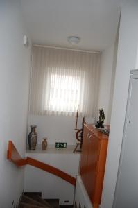 Habitación con escalera, ventana y estante. en Penzion Pri Slovenc en Dol pri Ljubljani