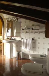 La salle de bains est pourvue d'un lavabo, de toilettes et d'un miroir. dans l'établissement Hotel Palacio Obispo, à Fontarrabie
