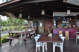 Un restaurante con mesas y sillas de madera y un bar. en Frangipani Apartment, en Christ Church