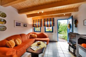 uma sala de estar com um sofá e uma televisão em Landhaus Will em Hilders