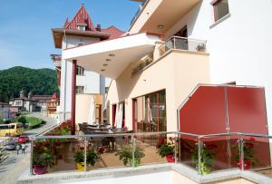 a balcony of a building with flowers and plants at Hotel Nemira in Slănic-Moldova