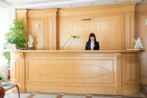 a woman is standing behind a podium at Hotel Nemira in Slănic-Moldova