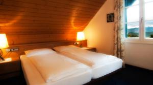 Cama en habitación con ventana en Hotel Latemar, en Soprabolzano