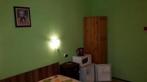 Zielony pokój z łóżkiem i kuchenką mikrofalową w obiekcie Dom Lidiya w mieście Pomorie