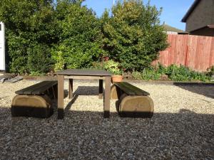 a picnic table and two benches in a yard at Lantern House in Cambridge