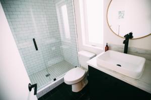 a bathroom with a toilet and a sink and a mirror at Noon on Sunset Hill in Los Angeles +36 photos
