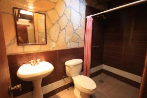 a bathroom with a toilet and a sink and a mirror at Hotel & Cava La Parroquia in San Cristóbal de Las Casas