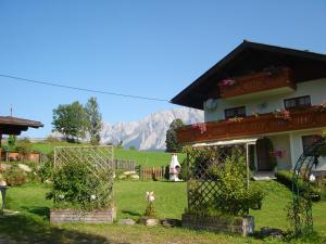 a house with a fence in a yard with mountains in the background at Alpenblick in Schladming