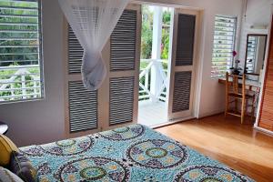a bedroom with a bed in a room with windows at Oasis Marigot in Marigot Bay
