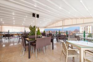 a restaurant with tables and chairs on a roof at Hotel Green Center Gili in Gostivar