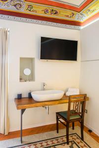 a bathroom with a sink and a chair and a television at Residenza Savianna in Sciacca