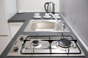a kitchen counter with a stove with a sink at Residenza Savianna in Sciacca