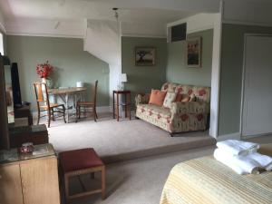 uma sala de estar com um sofá e uma mesa em Cliff Farmhouse B&B Suites em Hunstanton