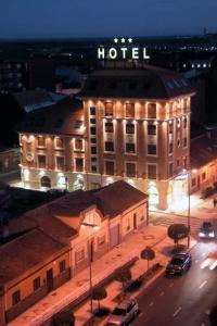 un bâtiment avec un hôtel la nuit avec des lumières dans l'établissement Hotel Santiago, à Benavente