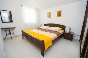 a bedroom with a bed and a table in it at Apartmani Pavo in Vodice