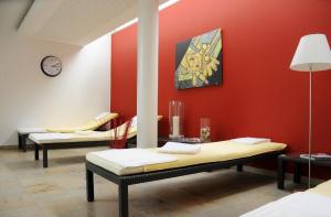 Hotel Restaurant Sengscheider Hof في زانكت إنغبرت: غرفة مع كرسيين مقابل جدار احمر