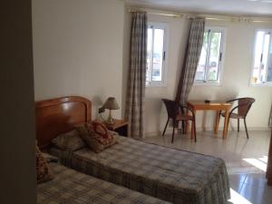 um quarto com uma cama, uma mesa e cadeiras em Motel Paris Dakar em Selouane